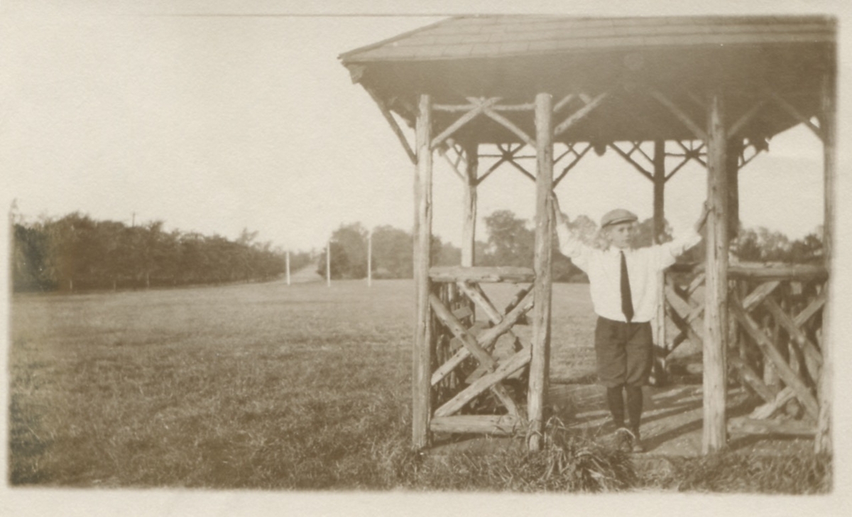 Robert Nelson (född 1908) poserar under en träställning ute på en äng, USA i september 1917. Son till Carl Nelson (född i Sverige, död i USA) och Alma Nelson (född 1881 i Kållered - död 1959 i USA).