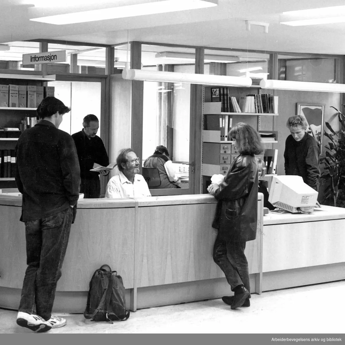 Arbeiderbevegelsens arkiv og bibliotek. Bak skranken: Terje Halvorsen (i døra), Kåre Auale (sittende), Lill-Ann Jensen (på kontoret) og Lars Langengen (til høyre). 1992
