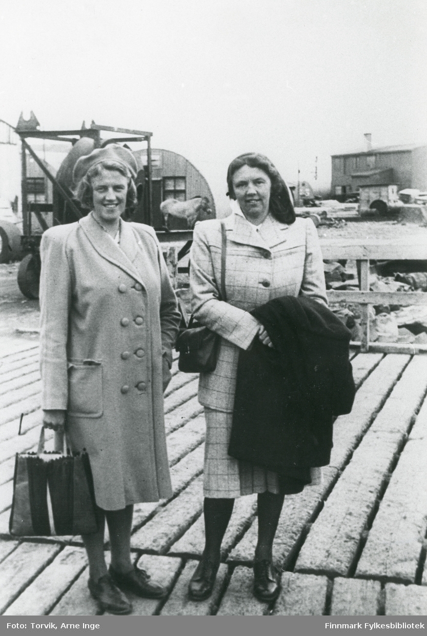 To damer står på dampskipskaia i Vadsø havn.