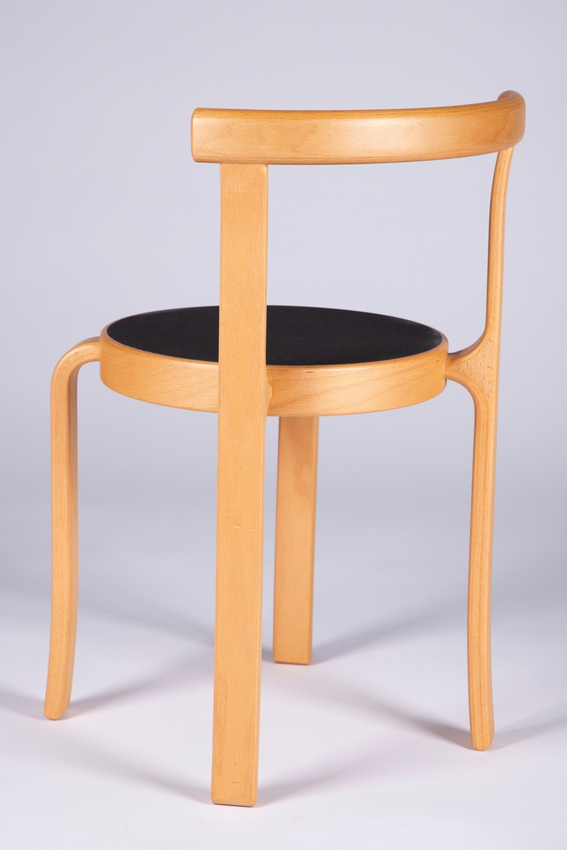 Barnestol i formbøyd og lakkert kryssfiner av bøk med svart sete av linoleum. Stolen har et halvsirkelformet rygglene som er festet til forlengelsen av de to bakre ben. Bena er kilt vinkelrett inn i setets kant og avrundet. Stolsetet er sirkelrundt og stolbena er plassert diagonalt på setet. Stolen kan stables.