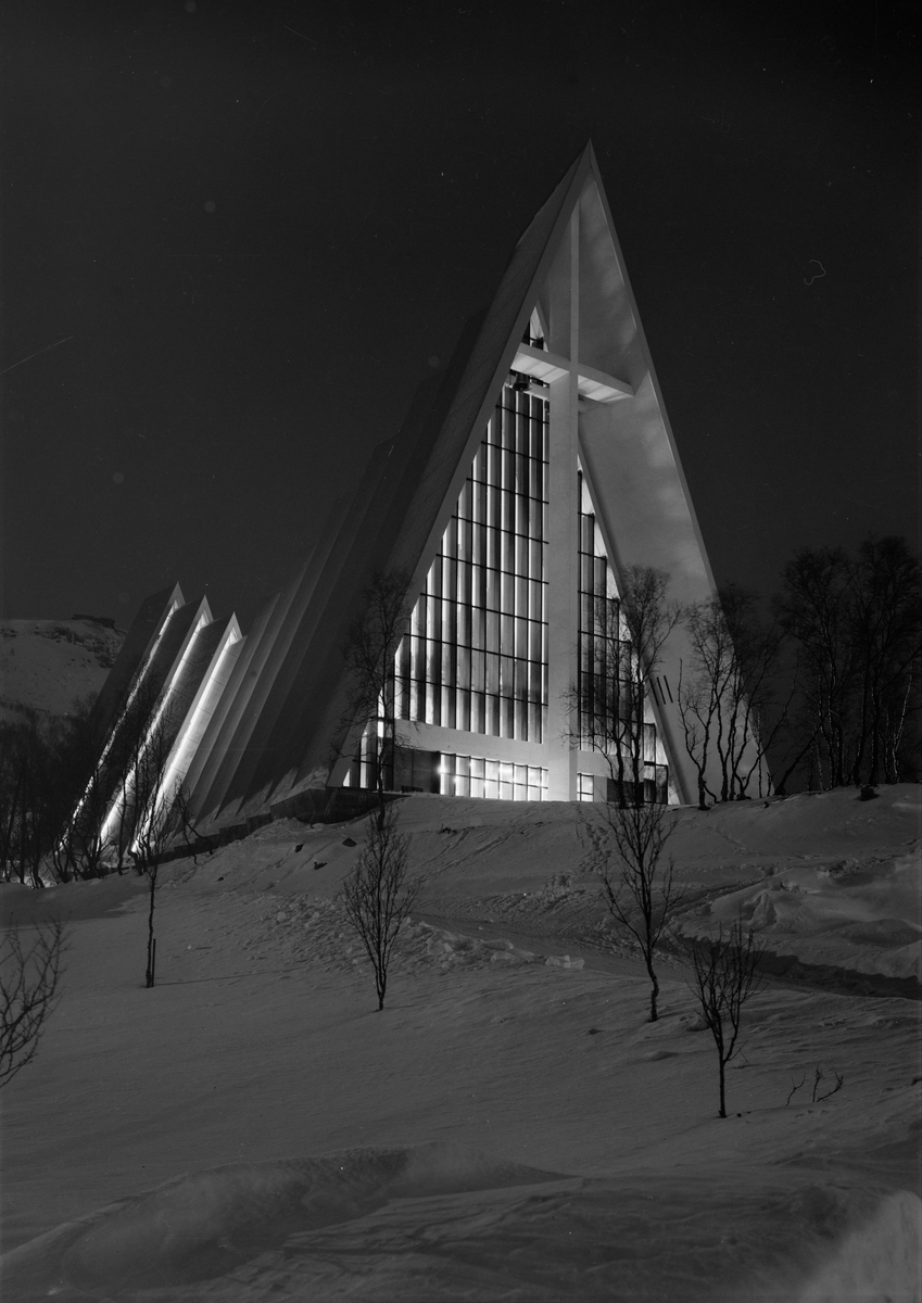 Arkitekturfoto av Tromsdalen kirke, bedre kjent som Ishavskatedralen. Med sitt avtrappede båthusformede eksteriør og sine åpne glassgavler er den blitt et landemerke i området. Kirken blei innviet 19 november 1965.