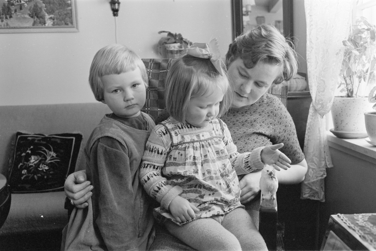 Portrett av en kvinne med to barn i en stue på Røros.