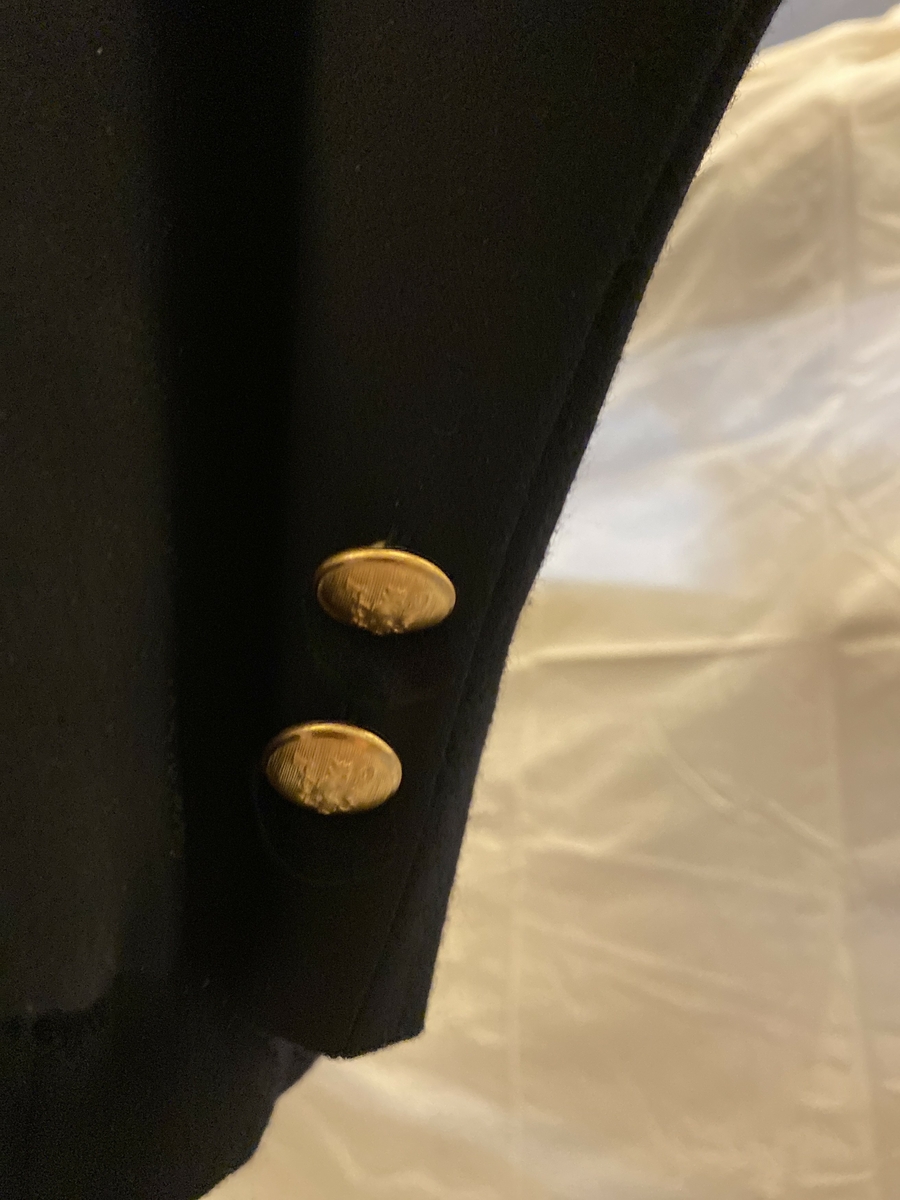 Uniformsjakke del av NSB-uniform, med lange ermer. Dobbeltspent. Gullknapper med Den norske løve. To knapper nederst på erme (på høyre erme mangler en av knappene). Jakken har ingen striper ellers på ermene.