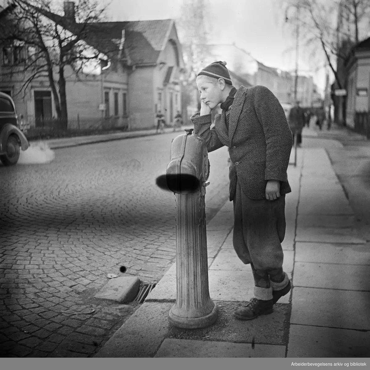 Storgata i Horten. Gutt lener seg mot en brannhydrant. 1948