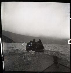 Fotografi av en motorbåt med fem menn som kjører ute på fjor