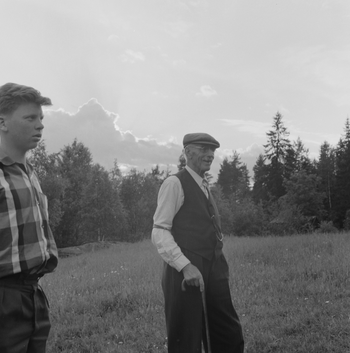 Ung og eldre mann går en tur på jordet. Holter og Halvor Nordby d.e.