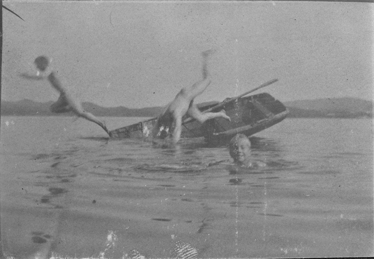 To som hopper fra en robåt ut i vannet