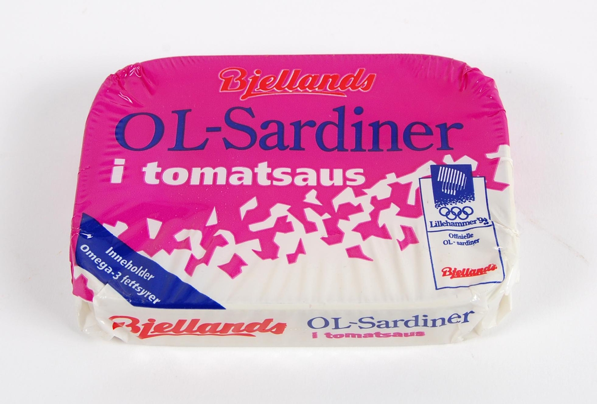 Sardinboks med forseglet embalasje. I boksen er det sardiner med tomatsaus. På embalasjen er det logo for de olympiske leker på Lillehammer i 1994 og Bjellands. Krystallmønster utgjør dekoren på embalasjen. Krystallmønsteret inngikk i LOOCs designprogram.