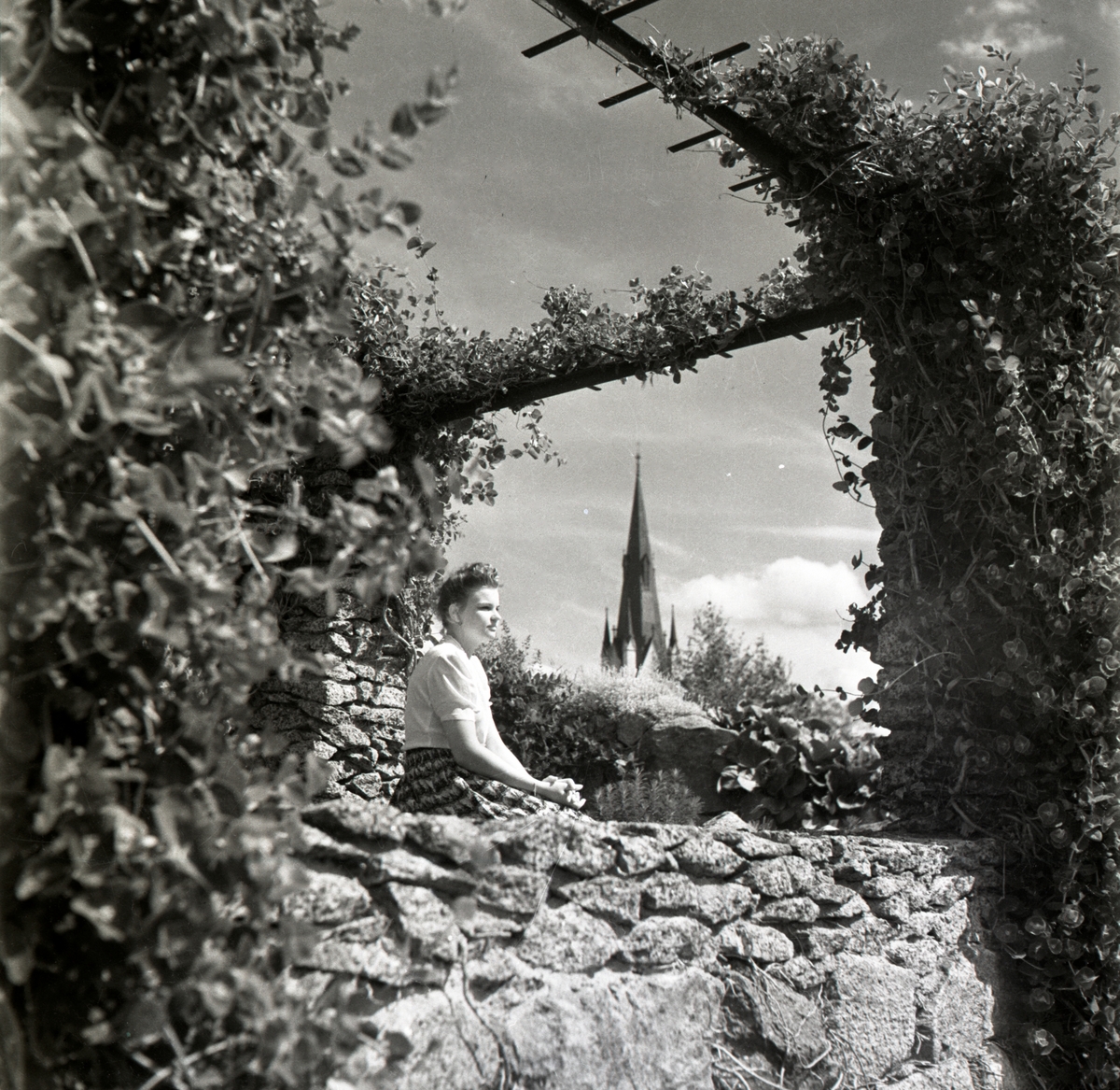 Parken vid Läroverket. Fru Mary Jagerwall sitter på stenmuren.