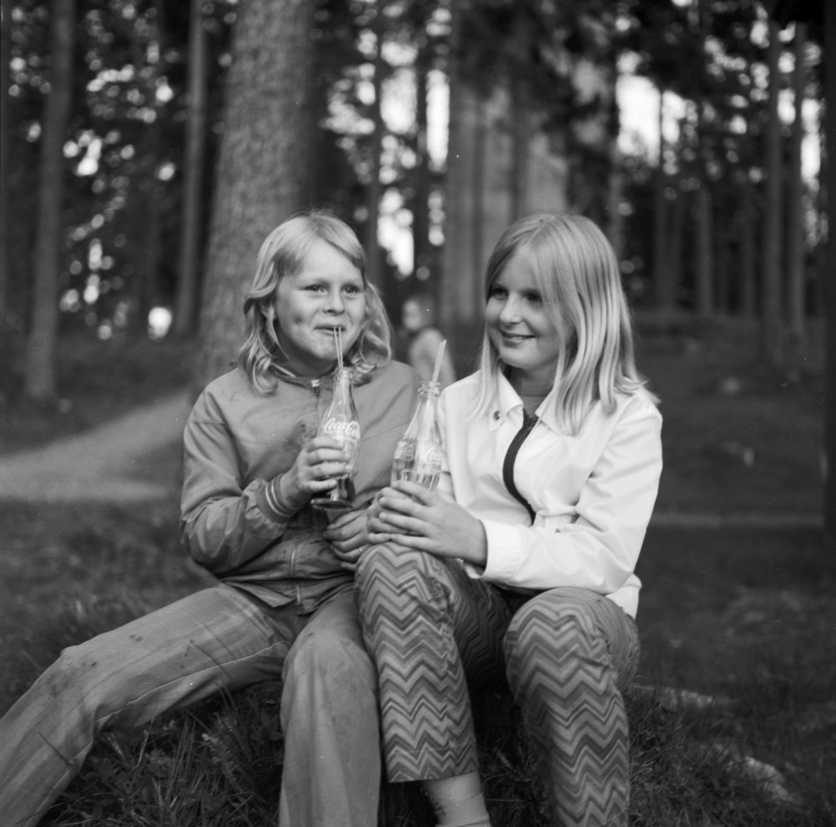 Två flickor sitter ute och dricker Coca-Cola ur flaska, Tierp, Uppland 1969