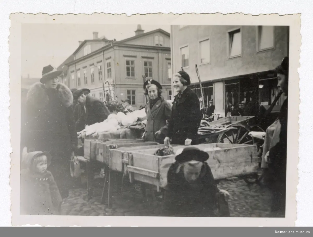 Doll och Gunnel Franzén säljer grönsaker på Stortorget i Kalmar, troligtvis 1930-40-tal. Påskrift baksida: Kalmar Stortorget Doll o Gunnel Franzén.