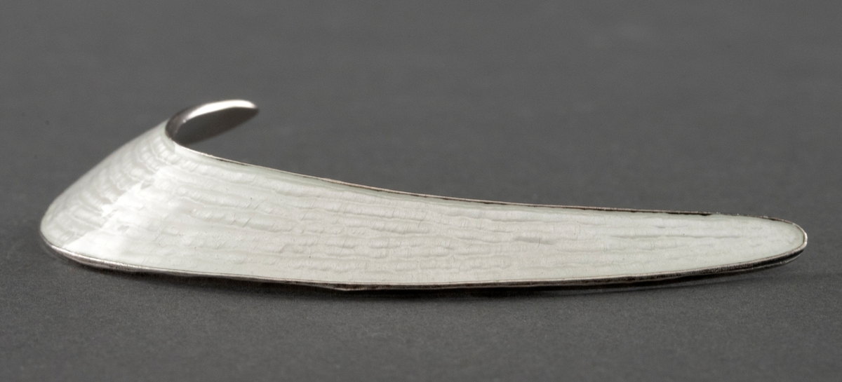 En halvmåneformet brosje i sølv sterling med hvit speilemalje.