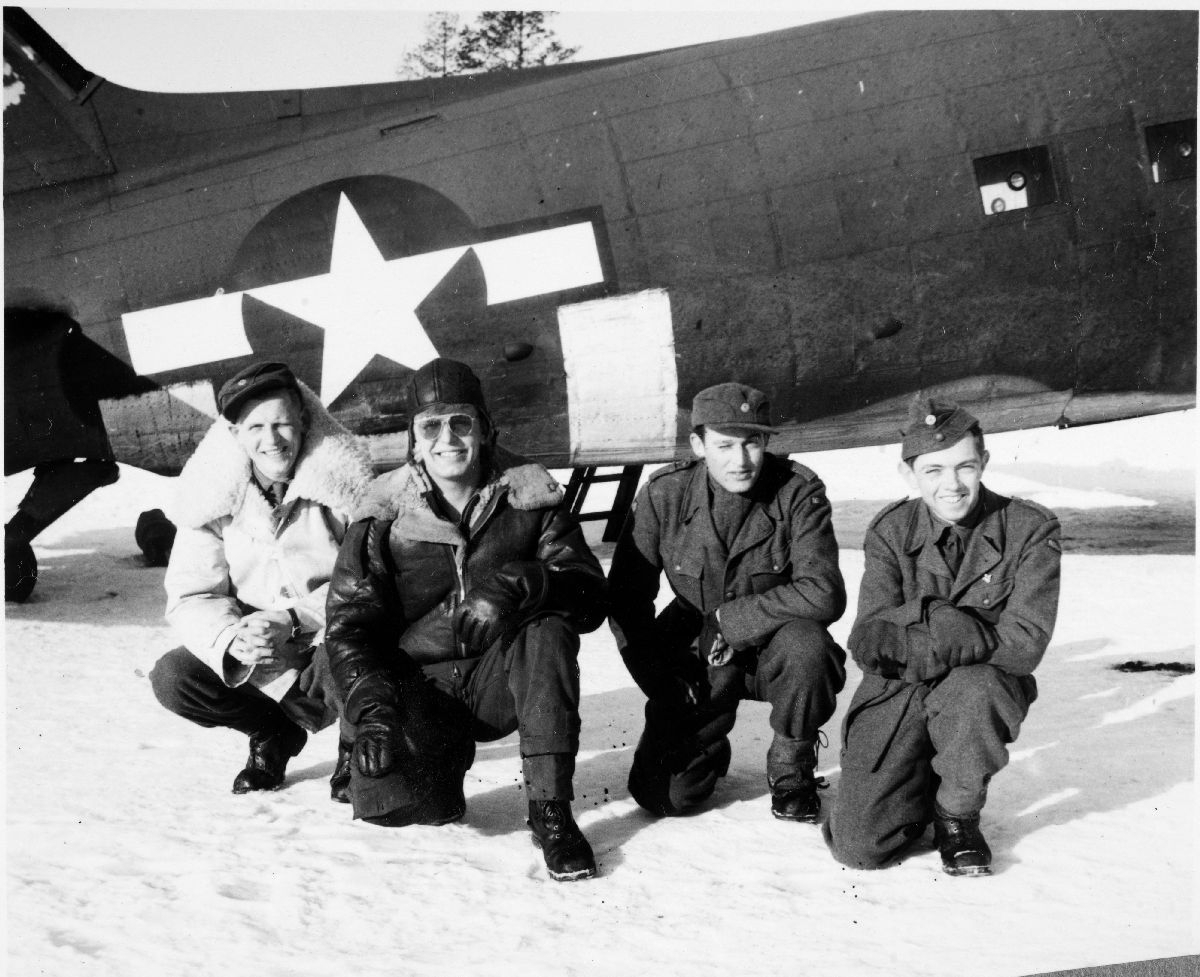 Fire besetningsmedlemmer oppstilt foran sitt DC-47 transportfly.