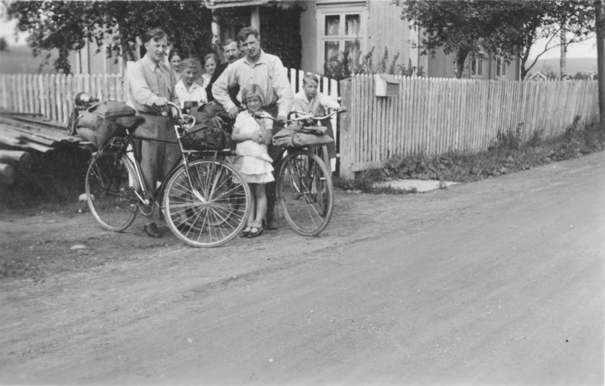 Voksne og barn fotografert i forbindelse med sykkeltur. Oppakning på bakasjebrettet