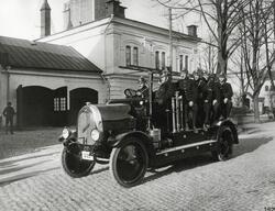 En brandbil med manskap vid dåv. brandstationen på Storgatan