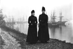 Kristine Broch og en venninne i yttertøy med hatt ved en str