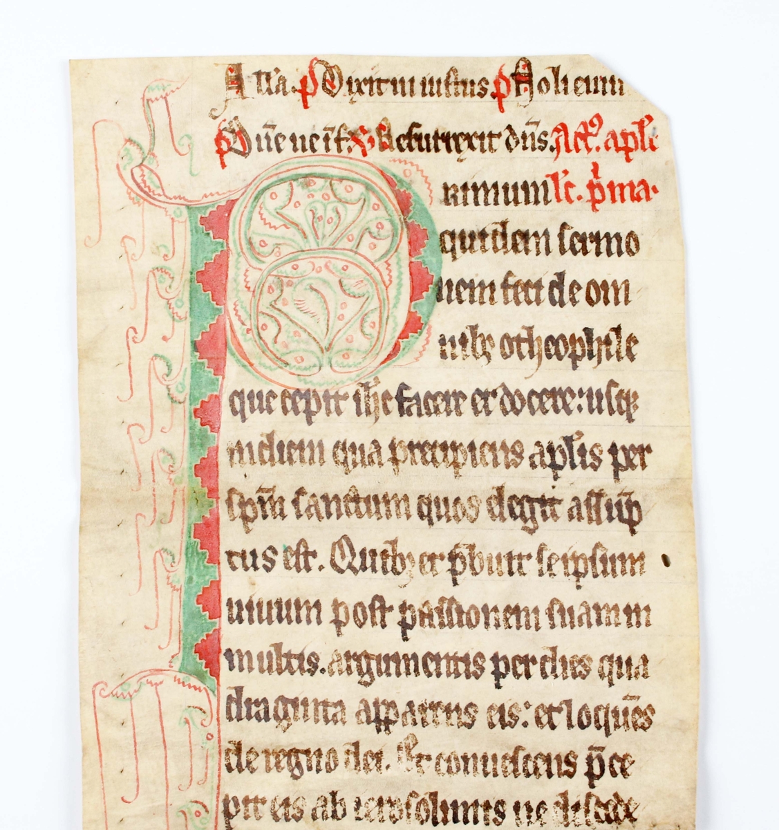 Blad ur mässbok "Missale" troligen 1200-tal. Tryckt i färgerna svart, rött och grönt mot benvitt pergament (djurhud). Bruks- och åldersslitage.