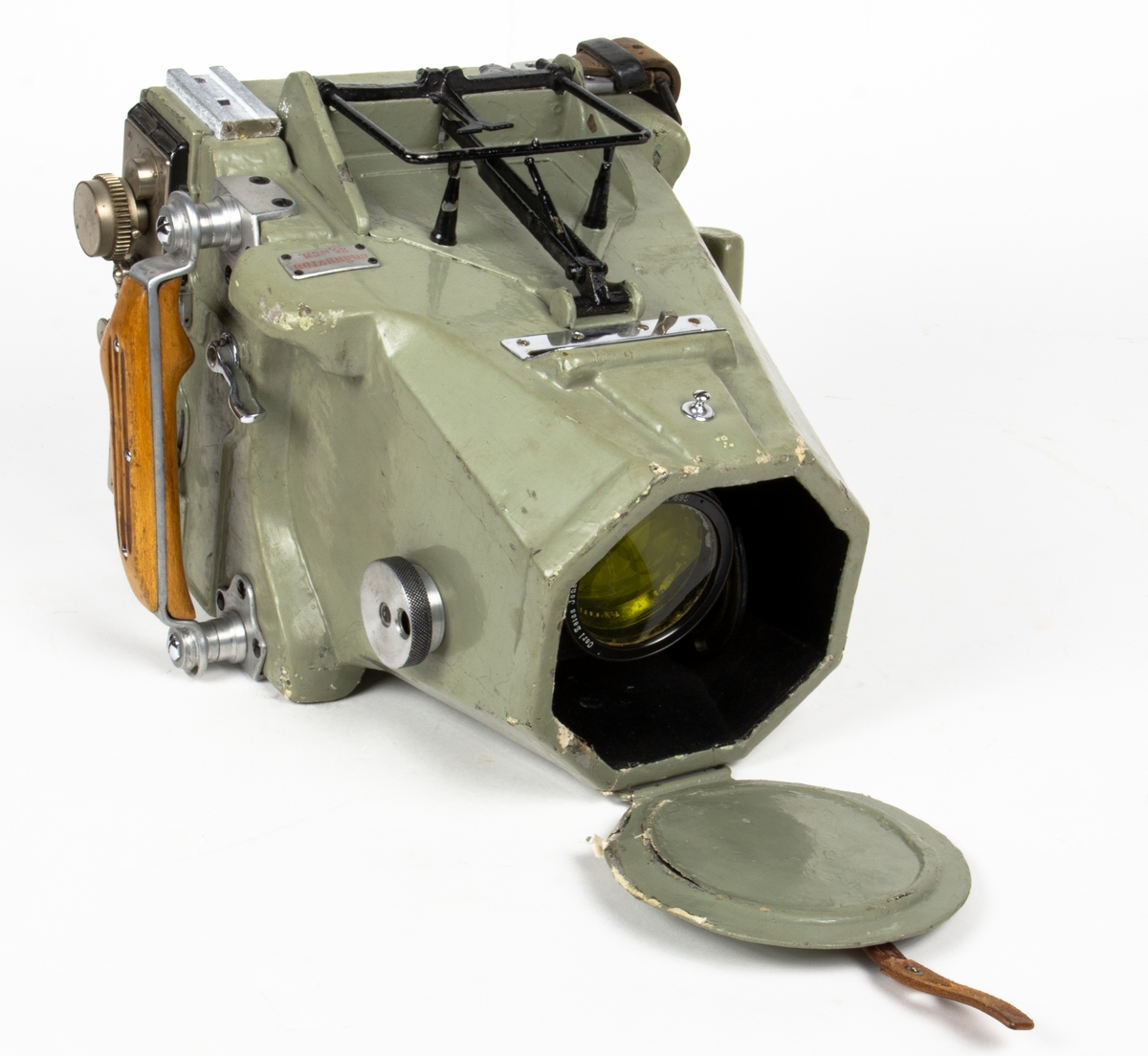 Handkamera Typ HK 1A. Lådformig kamera med läderrem på kamerans vänstra sida, samt trähandtag på dess högra sida. Utrustad med gulfilter och objektivskydd.
Präglad skylt på ovansida: BRÄNNVIDD 24,80 CM.
Tillverkningslogotyp på sidan: ZEISS-AEROTOPOGRAPH G.m.b.H. CARL ZEISS JENA
