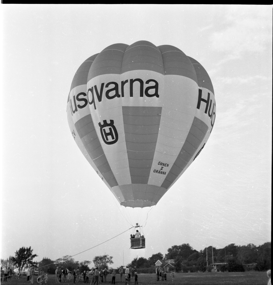 En förankrad luftballong över en gräsplan. Det är ballongen Örnen II från Gränna med reklam för Husqvarna.