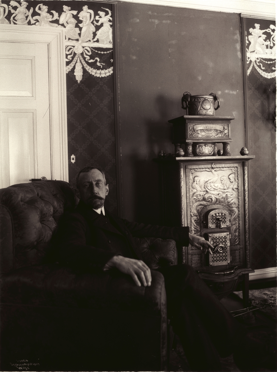 Roald Amundsen sittende ved kaminen i stuen på Uranienborg 7. mars 1909.
