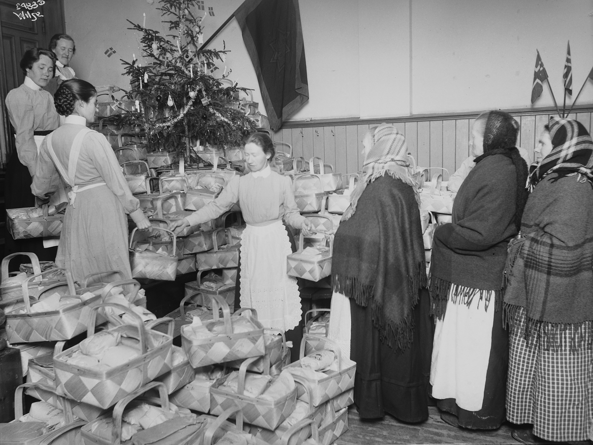Frelsesarméen sørger for utdeling av sponkurver med mat til eldre kvinner i forbindelse med jul. Fotografert 1911.