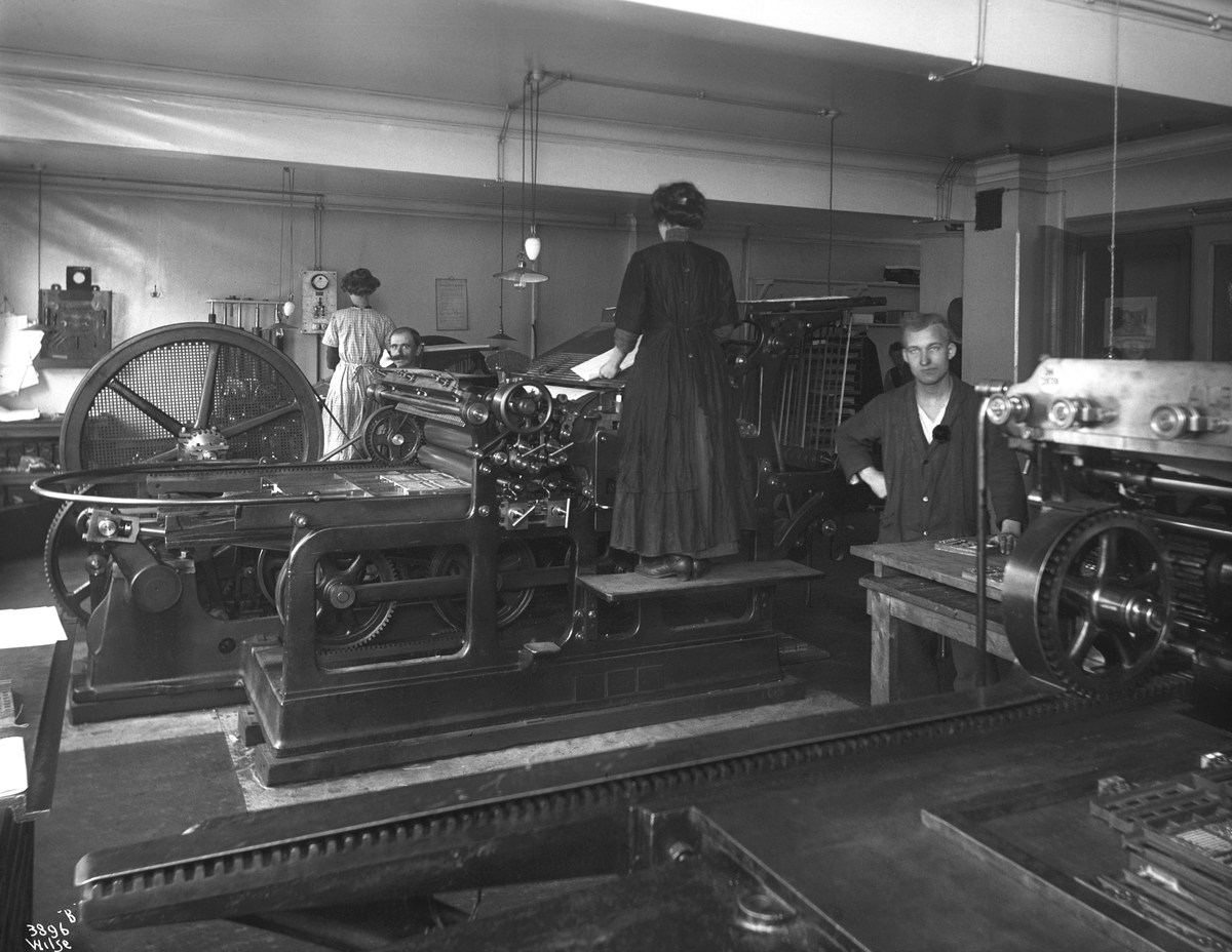 Arbeidere ved Moestues Trykkeri i arbeid ved de storee trykkerimaskinene.