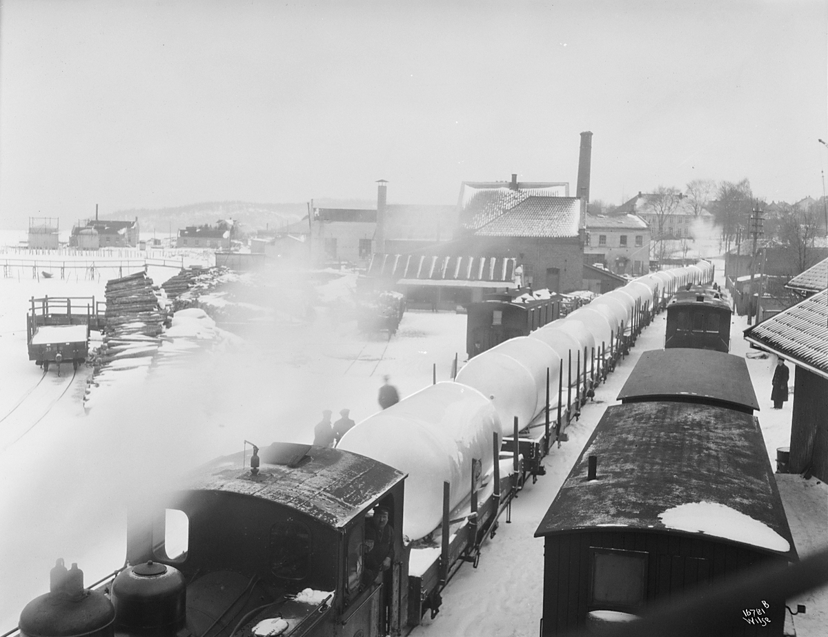 Flere godstog lastet med aluminium har stoppet på stasjon. Ekstern ref: Holmestrand-Vittingsfossbanens stasjon på havna i Holmestrand. Fotografert 1923.
