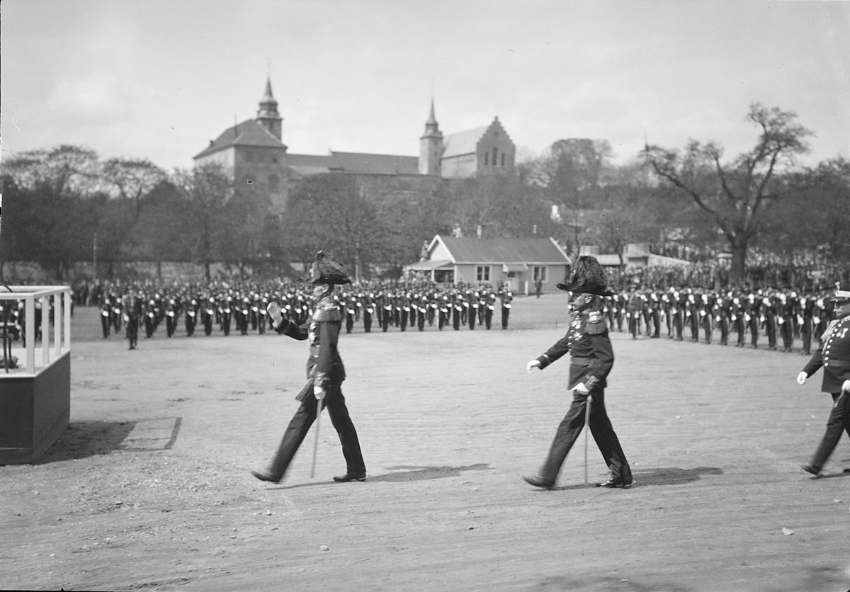 Kong Haakon VII marsjerer mot podiet, H. M. Kongens garde står i bakgrunn. Fotografert 1923.