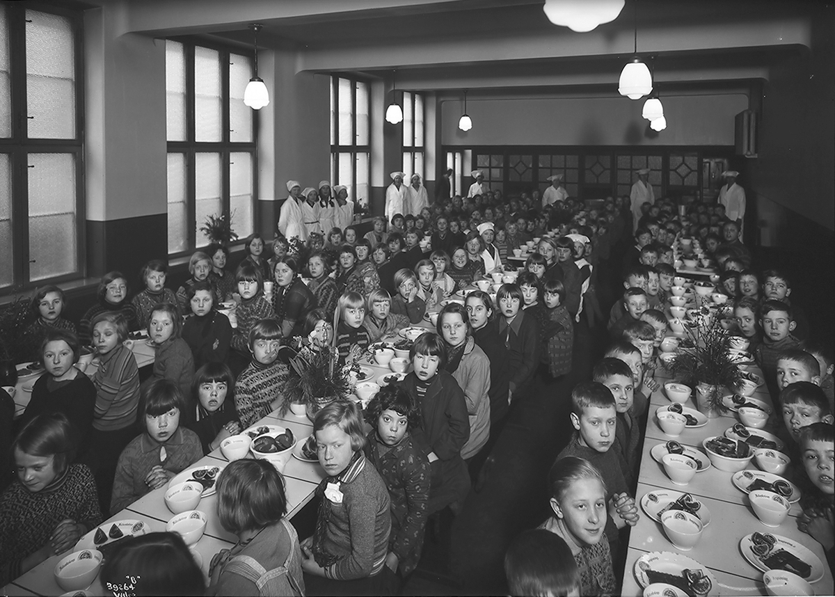 Skolefrokost på Herslebs skole i Oslo.  Alle elevene samlet i skolens kantine.  Kjøkkenpersonale sørger for ro og orden i tillegg til sunn og næringsrik mat.