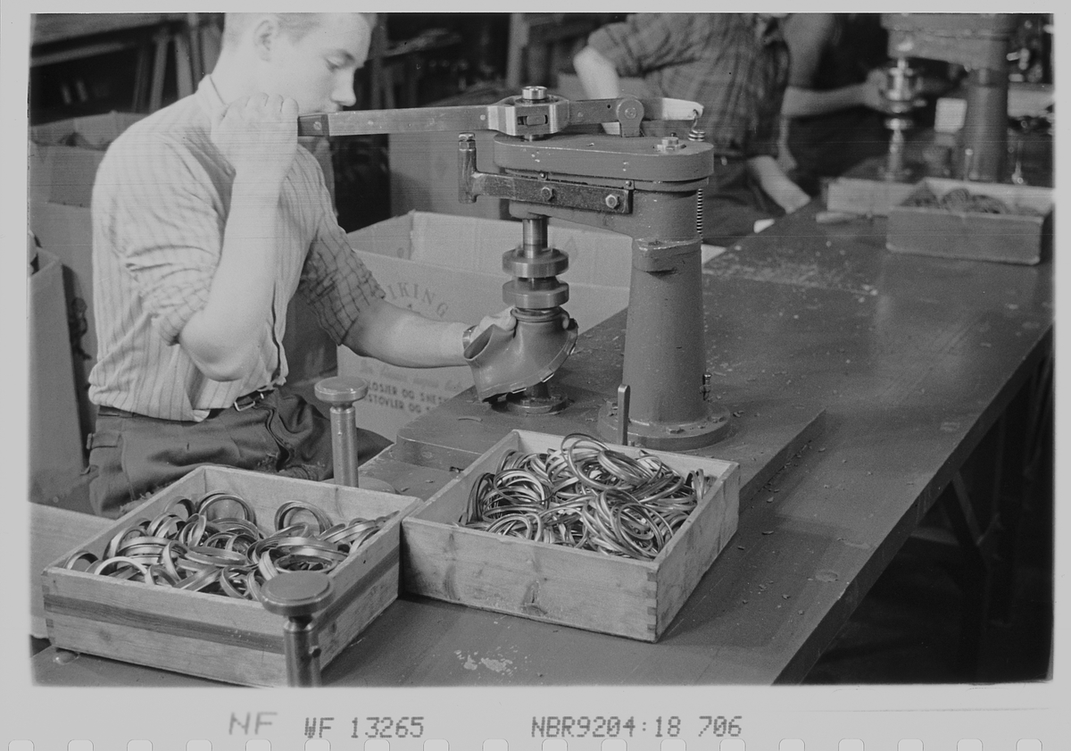 Mannlig arbeider ved gassmaskeproduksjonen ved Askim Gummivarefabrikk. Fotografert 1940.