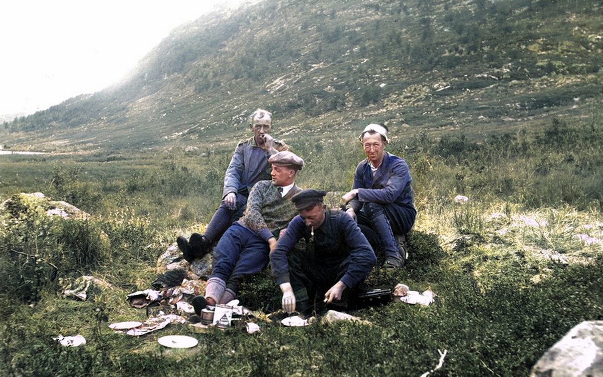 Kulørt bilde som viser fire menn på tur ved Nakkevannet, nær Tromsø. Fra venstre: Oscar Haugen, ukjent mann, Johan Johansen og Salomon Shotland (med kasserolle (?) på hodet).