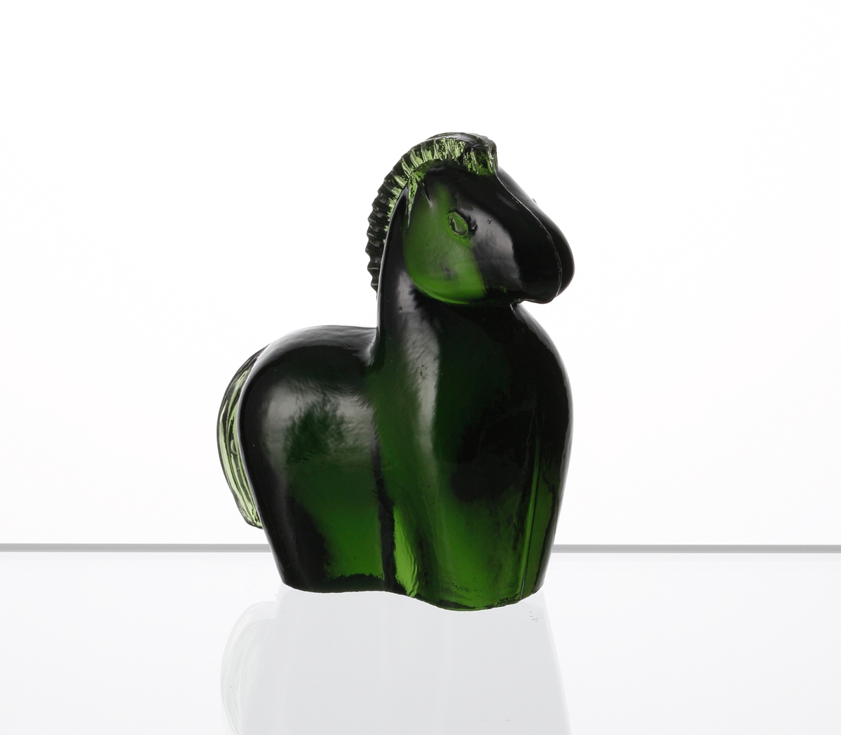 Formgiven av Kjell Blomberg. Mindre figuring i grönt glas, föreställande en häst.
