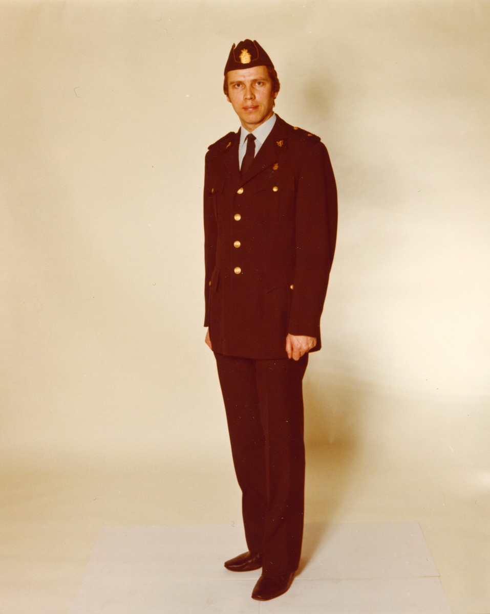 Politimann iført politiuniform M/1963 med blå skjorte og båtlue M/1969.