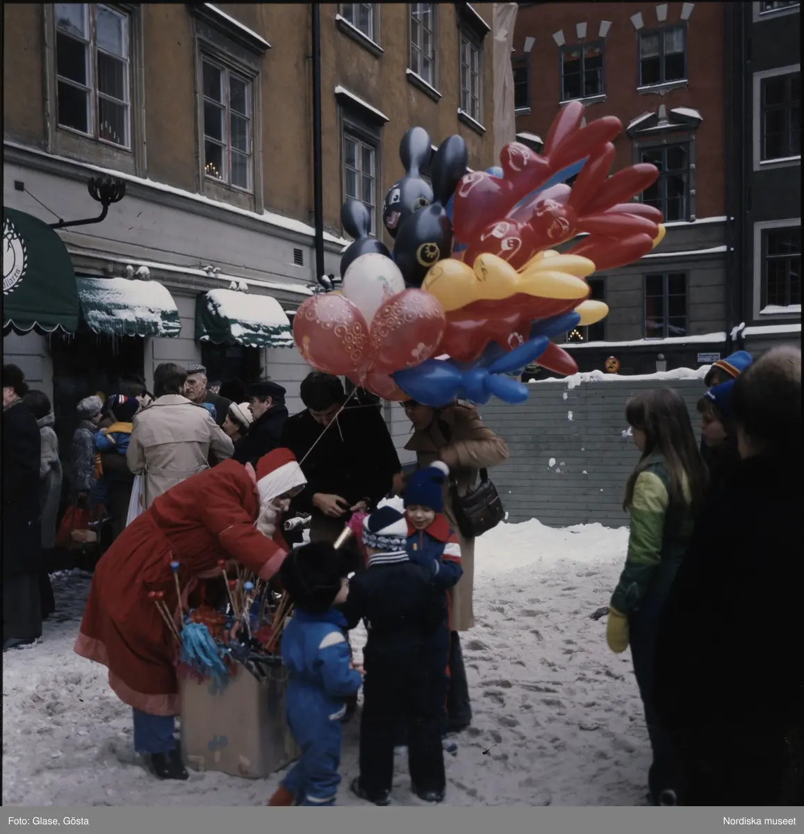 Barn samlade runt en tomte med ett fång ballonger. - Nordiska museet ...