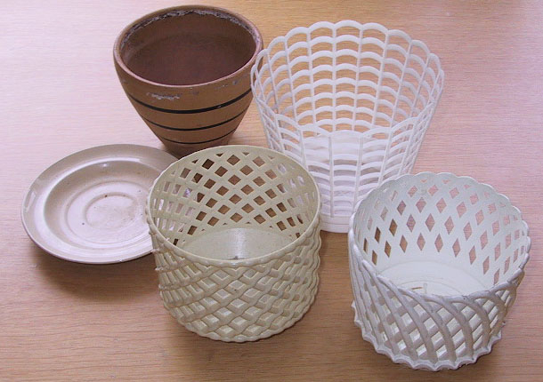 Fire potteskjulere, en av keramikk, en av myk plast og to av hard plast, ei skål.