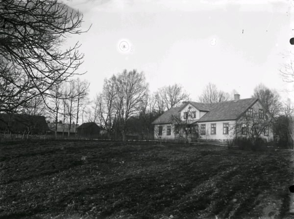 Drängsereds prästgård. Bild 1: Mia Lindeskog sitter vid ett buskage i trädgården med ett österikiskt krigsbarn ca 1920. Bild 2: Prästgården sedd från andra hållet med en plöjd åker i förgrunden.