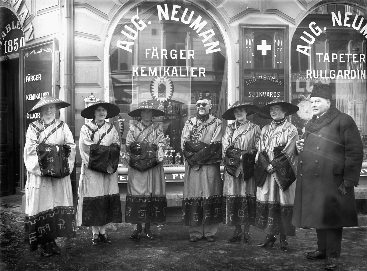 Offensiv reklamkampanj för fruktsaltet Mandarin vid Neumans färgaffär i Linköping 1928. Den icke utklädde mannen till höger antas vara direktör Gustaf Mauritz Neuman, son till firmans grundare.