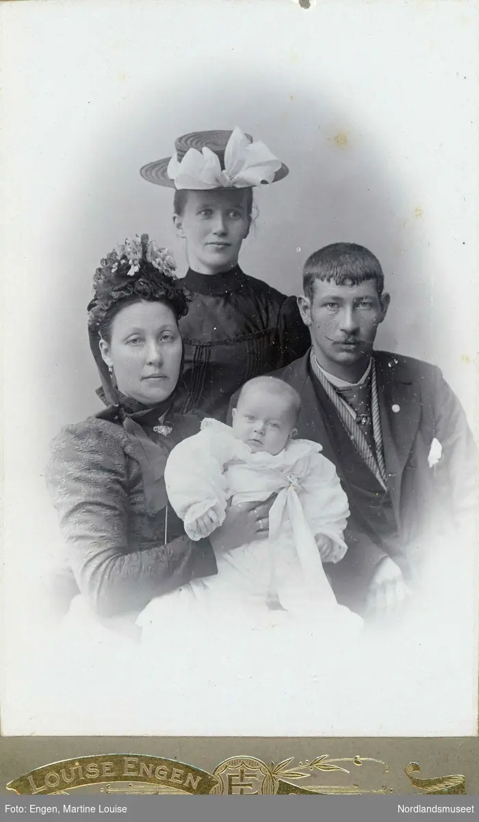 Portrett av to kvinner, en mann og en baby. Bildet er tatt i forbindelse med barnedåp.