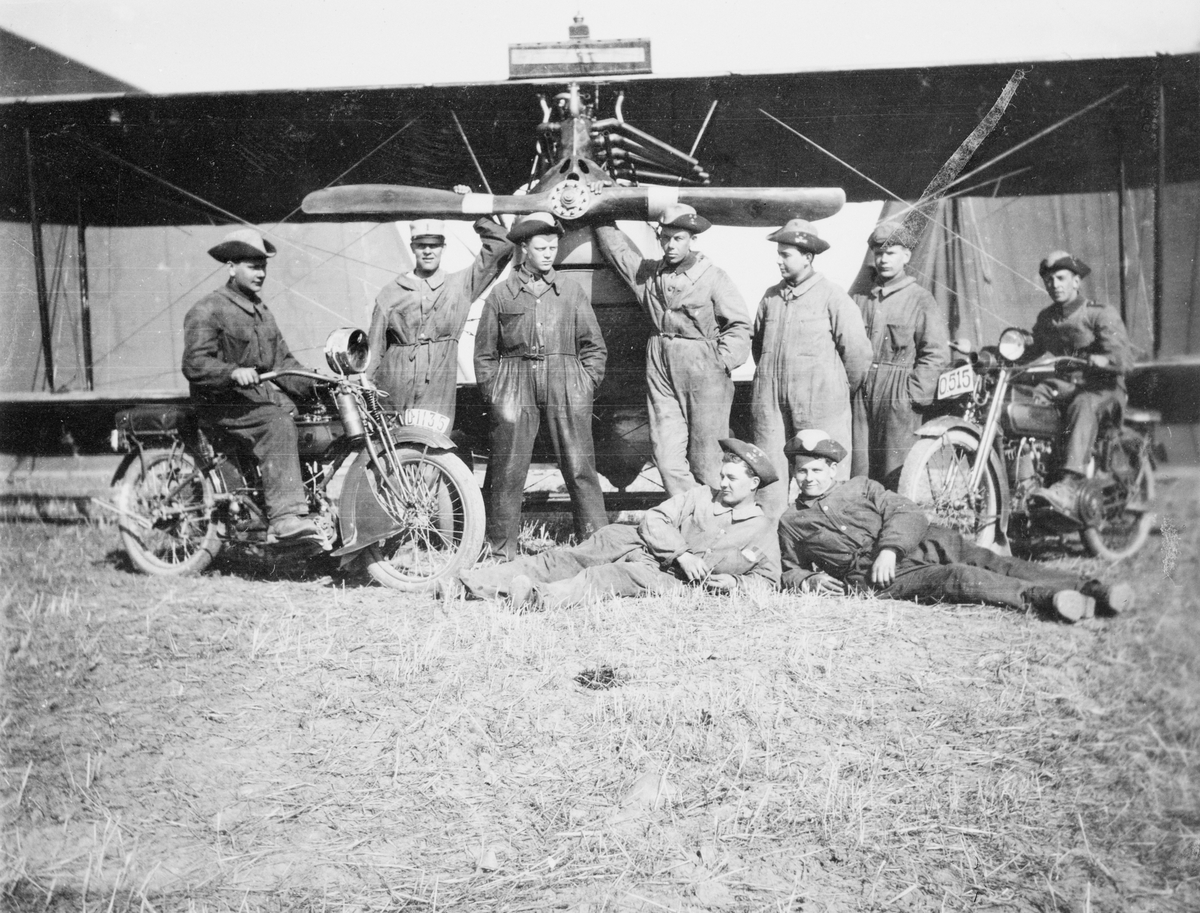Gruppfoto av manskap vid Flygkompaniet på Malmen omkring 1920. 9 män framför flygplan Albatros, varav två sittandes på motorcykel.