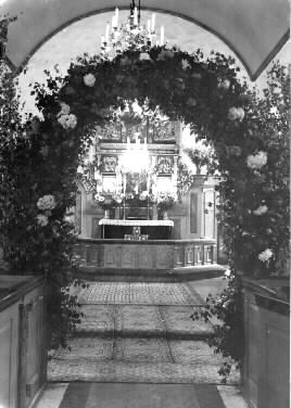 Interiör av Rolfstorps kyrka i samband med musikdirektör Nils Sjöbloms bröllop, andra giftet med Ester, född Levén. En ärebåge står längst fram över korgången vid kyrkbänkarna. (Se även GB2_3392-3395.)