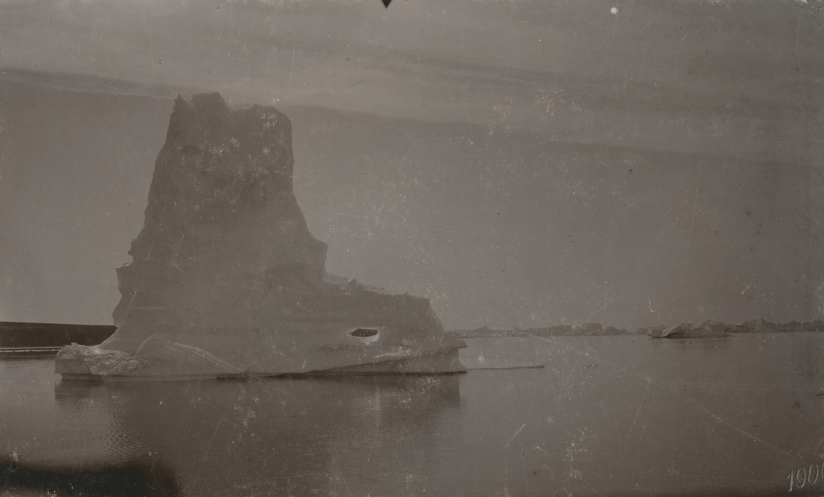 Fotografi från expedition till Grönland. Motiv av isberg i Scoresby sund, grönländska Kangertittivaq, som är världens längsta fjord och ligger på den östra delen av Grönland. Bilden är tagen år 1900.