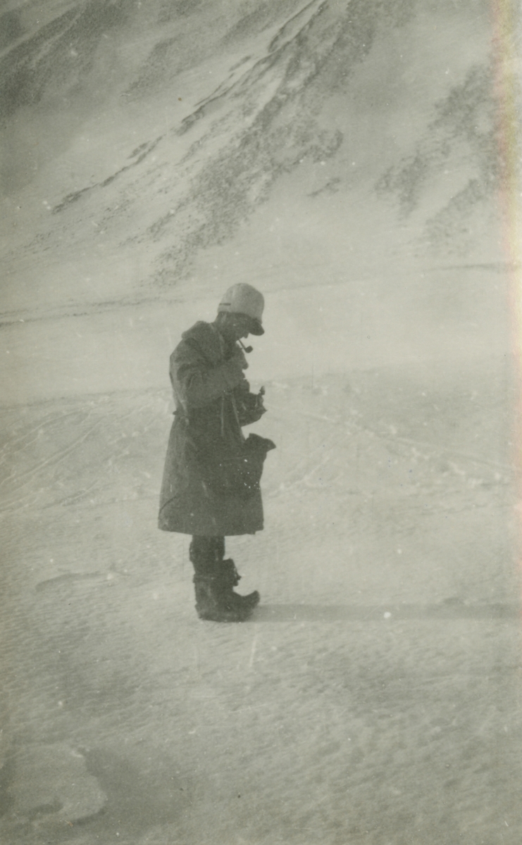 Fotografi från expedition till Spetsbergen. Motiv av man som står i isigt bergslandskap.