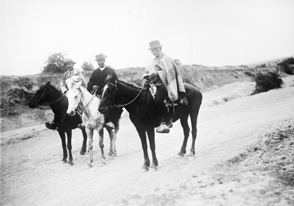 Fotografi från Eldslandet. Motiv av tre män till häst.