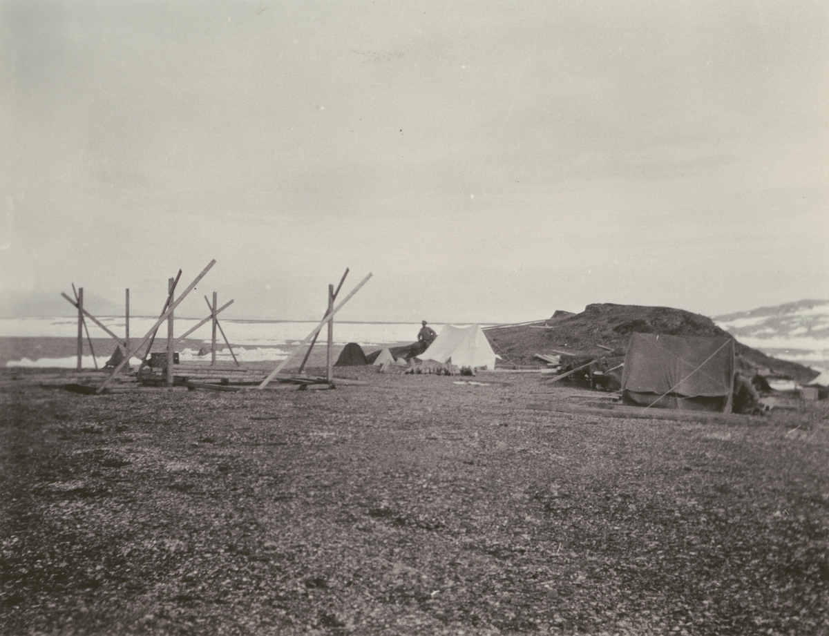 Fotografi från Ahlmannexpeditionen 1931. Motiv av lägerbygge i kargt landskap.