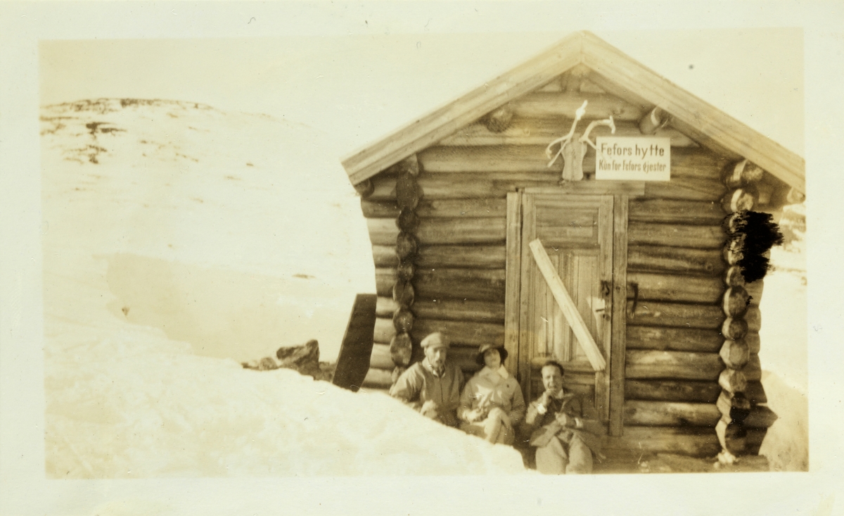 Johan Heuch Bugge, Mimi Egeberg(antatt) og Erling Bredal hviler ved liten bu på vei til eller fra fjelltoppen Ruten ved Fefor. Fotografert påsken 1926.