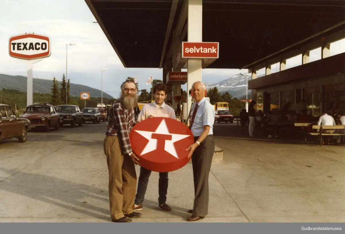 Markering av 25-års jubileet for Texaco-stasjonen på Dovre i 1985. Fra venstre grunnleggeren Arne Haugerud, sønnen Arne Henning og Torgeir Bjørstad, direktør for detaljhandel i Norsk Texaco.