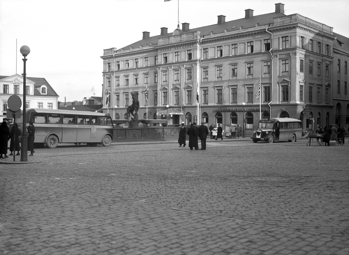 Vy över Stora torget i Linköping med Stora hotellet som fond. Året är 1936 och då som nu anlöpte busstrafiken torget frekvent. Perioden 1932-1945 stod upplysningsvis det privata bolaget AB Linköpings Omnibusstrafik för bussarnas stadstrafik. Den 1 januari 1946 kommunaliserades driften.