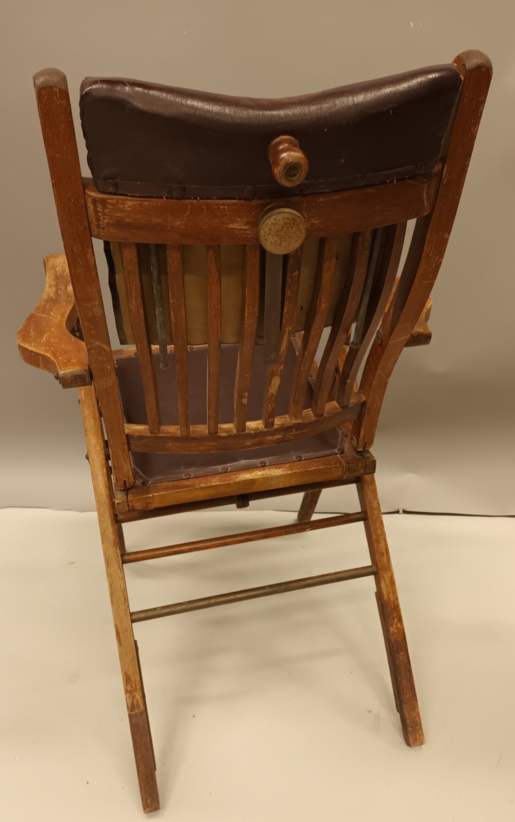 Stol i tre med skinnputer i rygg og sete. Høg rygg. Stolen er samanleggbar.