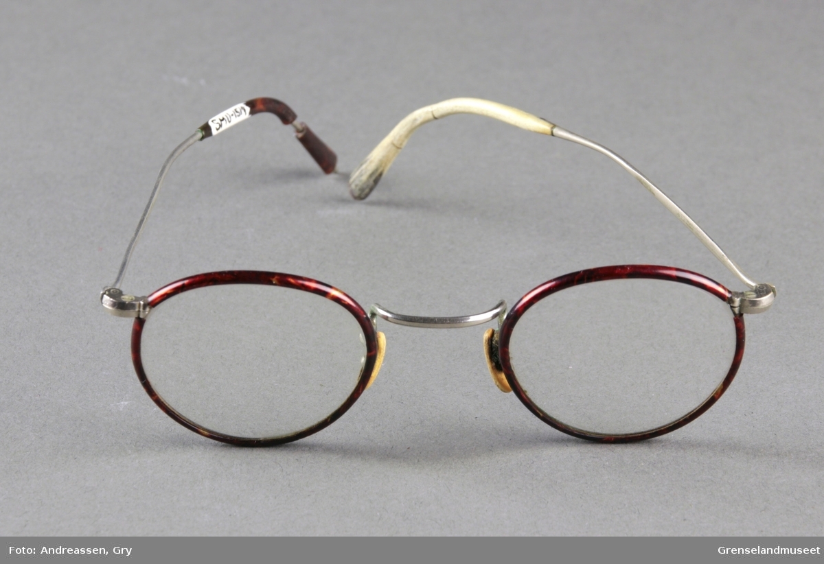 Små runde briller med en tynn brun innfatning i stål.