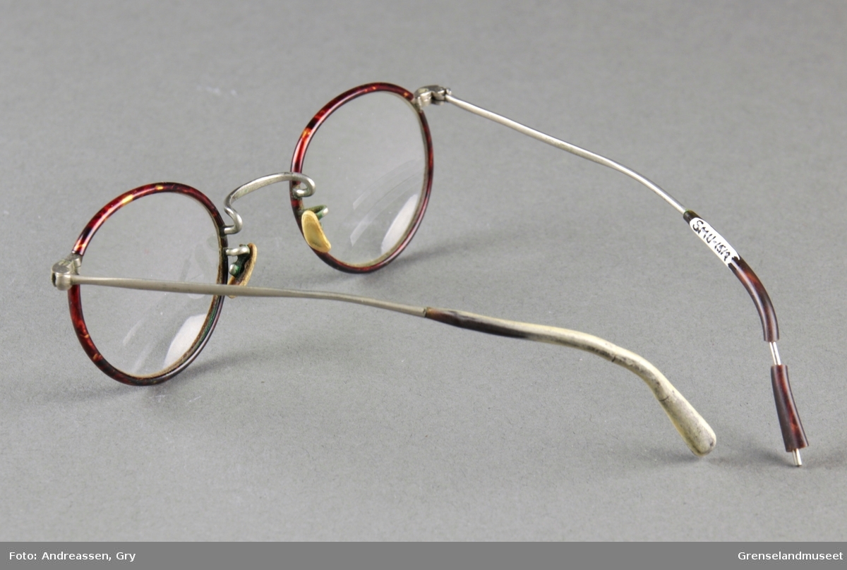 Små runde briller med en tynn brun innfatning i stål.